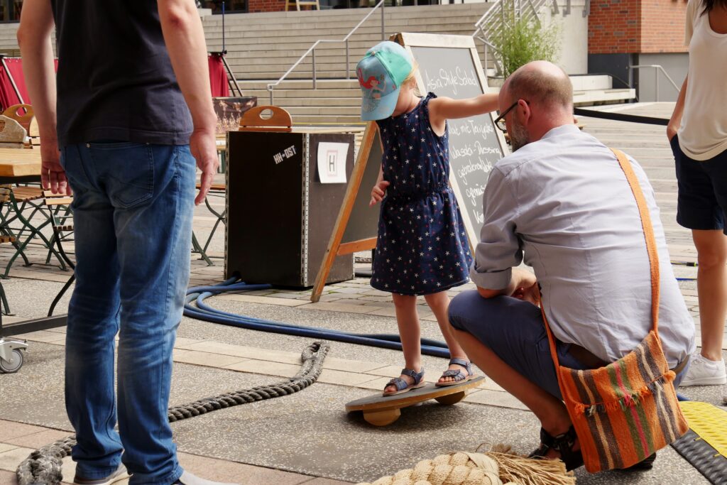 Mädchen übt ihre Seefestigkeit im Piraten Parkour am Vorplatz des Internationalen Maritimen Museum Hamburg. Der Familiensonntag ist Teil der Veranstaltungsreihe Sommer in der HafenCity.