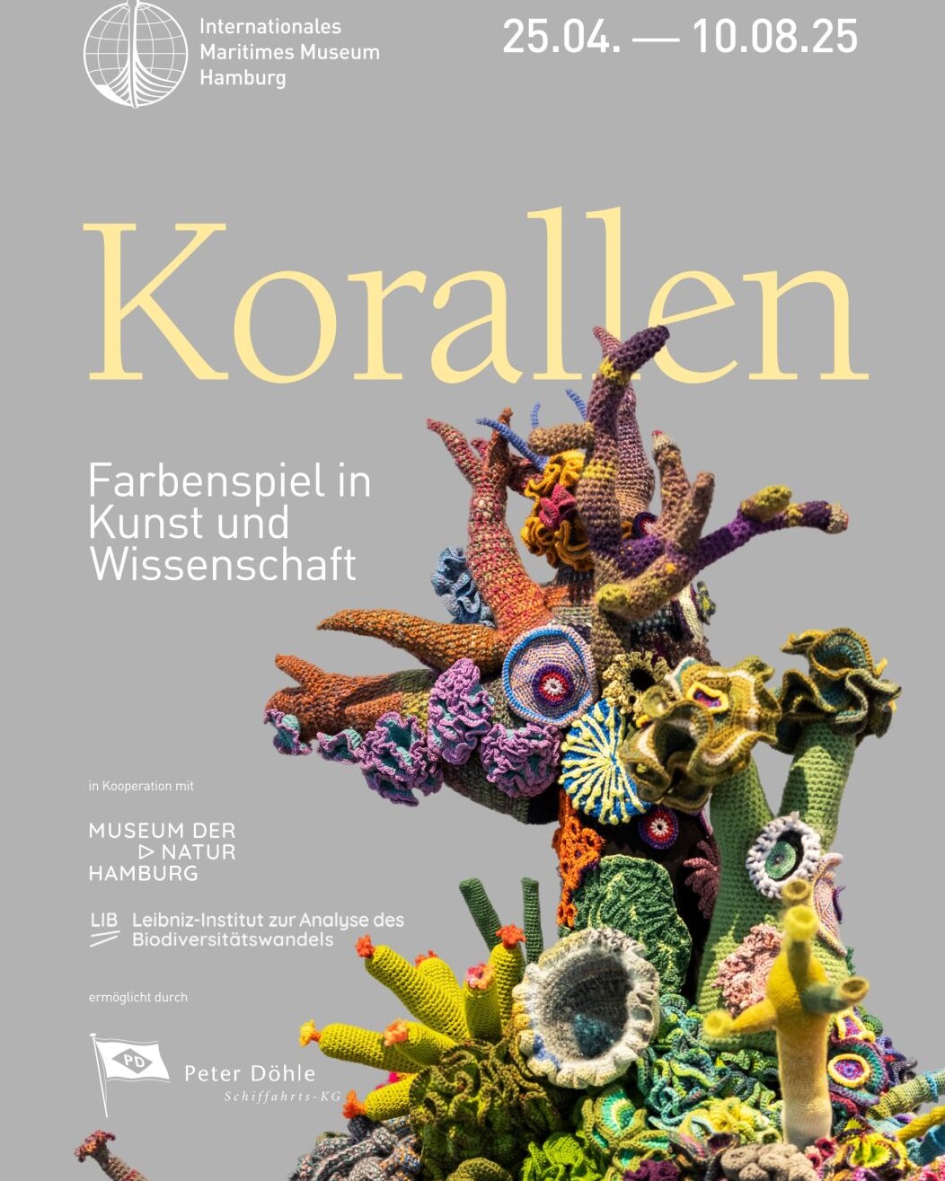 Plakat mit großer Überschrift „Korallen“, farbenfrohem, gehäkeltem Korallenriff vor grauem Hintergrund sowie Ausstellungsdaten und Museum-Logos.