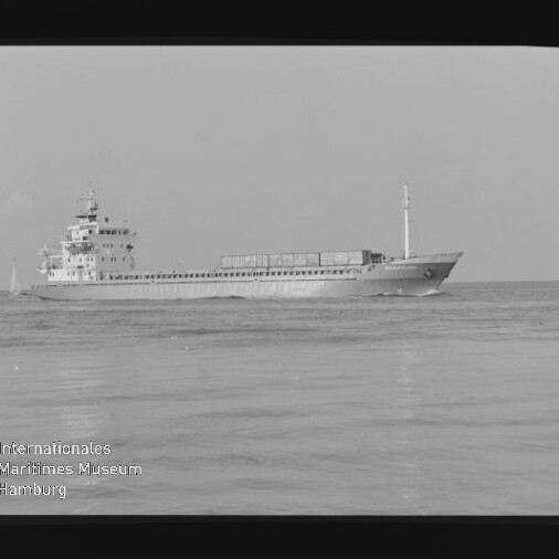 Frachtschiff seitlich auf ruhiger See, Schwarzweißaufnahme mit Schriftzug Internationales Maritimes Museum Hamburg unten links.