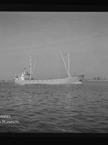 Frachtschiff mit zwei Masten auf ruhigem Wasser, Logo Internationales Maritimes Museum Hamburg sichtbar.