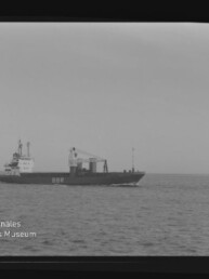Frachtschiff mit Aufschrift BBR fährt über ruhige See; Schwarzweiß-Aufnahme mit sichtbarem Filmrand und Museumslogo