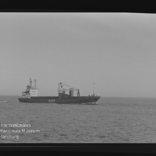 Frachtschiff mit Aufschrift BBR fährt über ruhige See; Schwarzweiß-Aufnahme mit sichtbarem Filmrand und Museumslogo