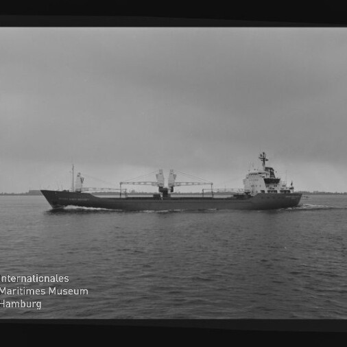 Schwarzweiß-Foto eines Frachtschiffs auf ruhiger See vor wolkigem Himmel; Filmrand mit AGFAPAN-Label und Museumssignet.
