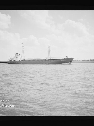 Schwarzweiß-Foto eines Frachtschiffs mit zwei Masten auf ruhiger See, quadratisch gerahmt; Museumslogo Internationales Maritimes Museum Hamburg sichtbar.