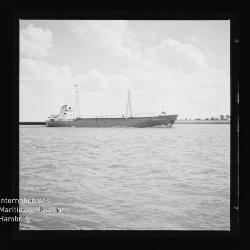 Schwarzweiß-Foto eines Frachtschiffs mit zwei Masten auf ruhiger See, quadratisch gerahmt; Museumslogo Internationales Maritimes Museum Hamburg sichtbar.