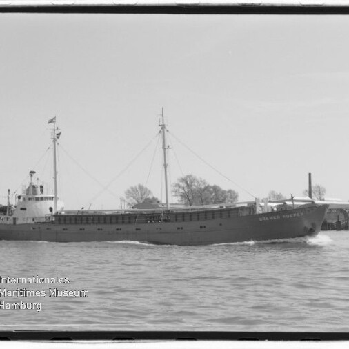 Frachtschiff mit zwei Masten fährt über ruhiges Wasser; schwarzweißes Foto mit Museums-Wasserzeichen.