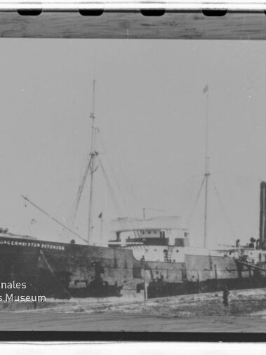 Gestrandetes Dampfschiff mit Schornstein und Masten; Name auf dem Rumpf und Museums‑Wasserzeichen sichtbar.