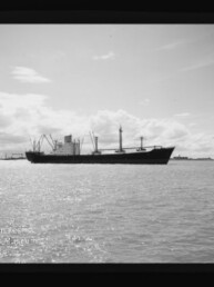 Schwarzweißaufnahme eines Frachtschiffs auf ruhiger See vor Wolken, mit Wasserzeichen des Maritimen Museums Hamburg.