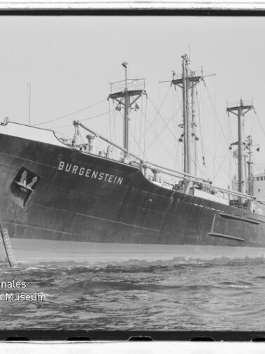 Frachtschiff BURGENSTEIN mit Kränen und Masten am Kai, Wellen im Vordergrund und Museumswasserzeichen unten links.