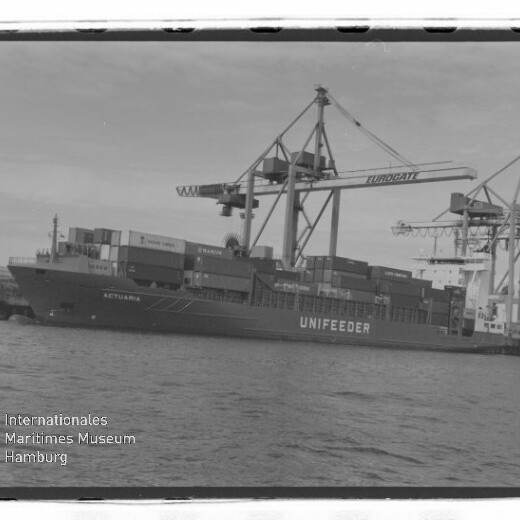 Containerschiff UNIFEEDER am Kai, beladen von großen Hafenkränen mit aufgetürmten Containern.