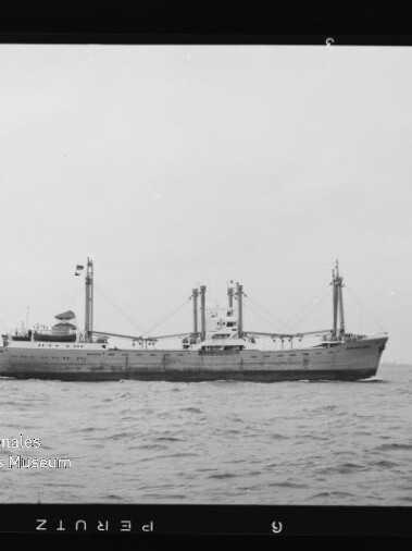 Älteres Frachtschiff in Seitenansicht auf ruhiger See; Schwarzweißfoto mit Wasserzeichen 'Maritimes Museum Hamburg'.