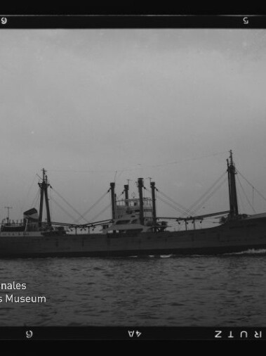 Schwarzweiß-Seitenansicht eines Frachtschiffs auf ruhiger See mit Logo des Internationalen Maritimen Museums Hamburg links.