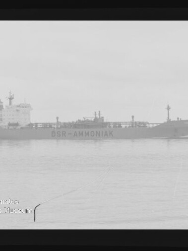 Schwarzweiß-Filmaufnahme eines Tankschiffs mit der Aufschrift DSR-AMMONIAK auf ruhiger See, sichtbarer Filmrand und Museumswasserzeichen.