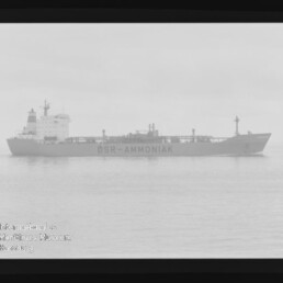 Schwarzweiß-Seitenansicht des Frachttankers DSR-AMMONIAK auf ruhiger See, mit Filmrand und Markierungen.