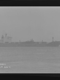 Silhouette eines Frachters/Tankers im nebligen Meer, Horizont kaum erkennbar; Wasserzeichen des Int. Maritimen Museums Hamburg.