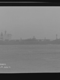 Nebeliger Frachter mit sichtbarem Schriftzug 'AMMONIAK' als Silhouette auf ruhiger See; Filmrand und Museumswasserzeichen.