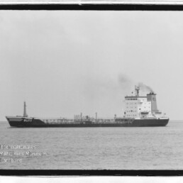 Schwarzweißaufnahme des Tankers BUTT auf ruhiger See mit rauchendem Schornstein und Wasserzeichen des Maritimen Museums Hamburg