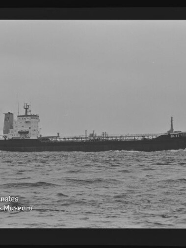 Tankerschiff auf ruhiger See in Schwarzweiß, mit sichtbaren Rohrleitungen und dem Namen GULF am Bug.