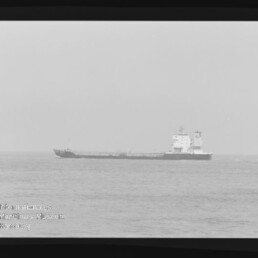 Schwarzweißaufnahme eines Tankschiffs in Seitenansicht auf ruhiger See, mit Filmrand und Stempel Internationales Maritimes Museum Hamburg.