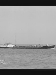 Schwarzweiß-Seitenansicht eines Frachtschiffs auf ruhiger See mit Horizont und Museumswasserzeichen