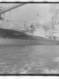 Großes Frachtschiff am Containerterminal unter Kränen, mit Wasserzeichen des Internationalen Maritimen Museums Hamburg.