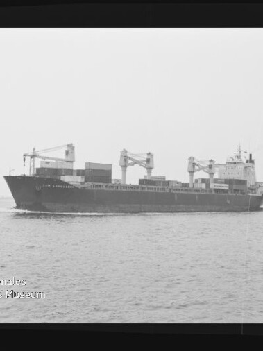 Schwarzweißfoto eines Frachtschiffs mit Bordkränen und Containern auf See; Wasserzeichen Internationales Maritimes Museum Hamburg.