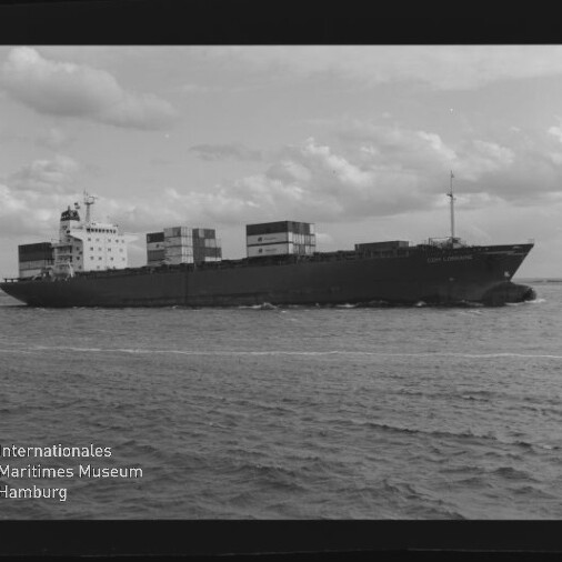 Containerschiff mit geladenen Containern fährt bei bewölktem Himmel; Schriftzug des Maritimen Museums Hamburg sichtbar.