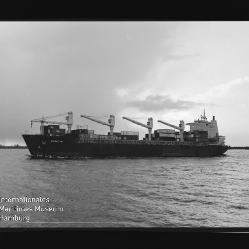 Schwarzweißfoto eines Containerschiffs mit drei Kränen auf dem Meer; Wasserzeichen Internationales Maritimes Museum.