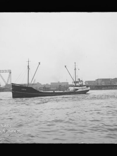 Schiff vor Industriehafen mit Kransilhouette und Brücke im Hintergrund; Wasserzeichen 