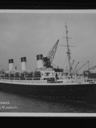 Großer Ozeandampfer mit drei Schornsteinen neben Kränen im Hafen; Schriftzug Internationales Maritimes Museum Hamburg links unten.