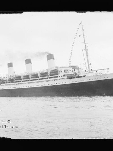 Historisches Passagierschiff mit drei Schornsteinen und geschmücktem Mast auf ruhiger See, Schwarzweiß.