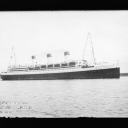 Großer Ozeandampfer mit drei Schornsteinen auf ruhiger See; schwarz-weißes Archivfoto.