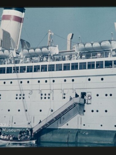 Passagierschiff mit Gangway und Rettungsbooten, kleine Barkasse am Wasser und Logo des Maritimen Museums Hamburg.
