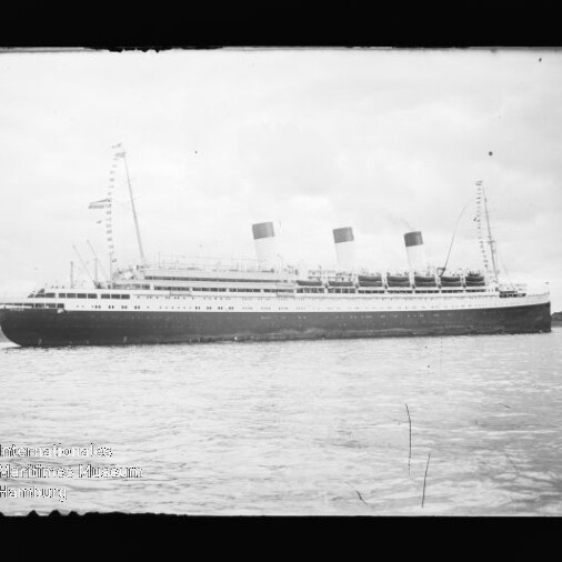 Seitenansicht eines historischen Passagierschiffs mit drei Schornsteinen auf ruhigem Wasser; Museumswasserzeichen unten links