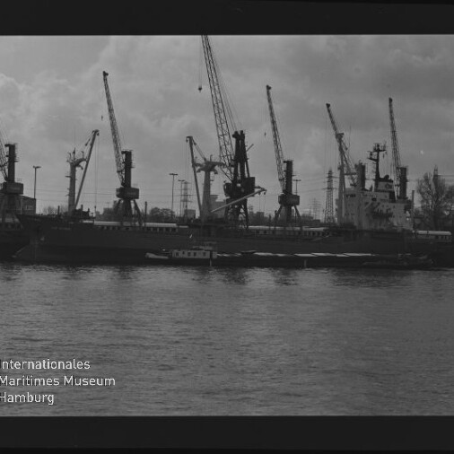 Hafen mit mehreren Kränen am Kai und einem Frachtschiff, davor Wasser und ein kleines Boot, Logo Maritimes Museum Hamburg.