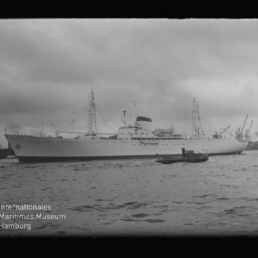Weißes Passagierschiff im Hafen, kleines Boot im Vordergrund, Hafenkräne im Hintergrund und Wasserzeichen Internationales Maritimes Museum Hamburg