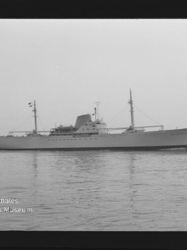Langes Schiff mit zwei Masten und markanten Aufbauten auf ruhigem Wasser; Wasserzeichen 'Internationales Maritimes Museum Hamburg'.