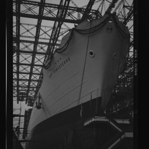Bug des Passagierschiffs C.H. Finisterre im Trockendock unter einem großen Stahlgerüst, mit Girlanden und Zuschauern.