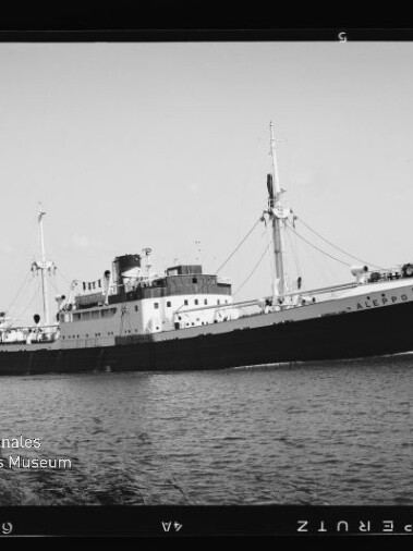 Frachtschiff ALEPPO in Profilansicht auf ruhigem Wasser, mit zwei Masten, Aufbauten und Museumslogo unten links.