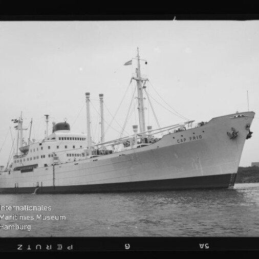 Großes Passagier- und Frachtschiff Cap Frio mit Masten und Schornstein nahe Küste, Schwarzweißaufnahme mit Museumslogo.