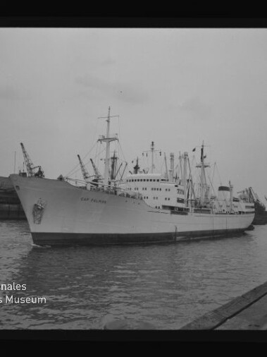 Großes Handelsschiff mit Aufschrift Cap Polonio liegt am Kai; Kräne im Hafen und Museumslogo unten links.