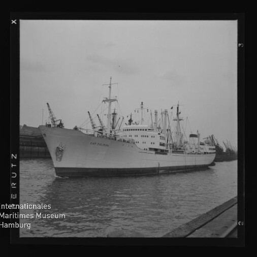 Großes Handelsschiff mit Aufschrift Cap Polonio liegt am Kai; Kräne im Hafen und Museumslogo unten links.