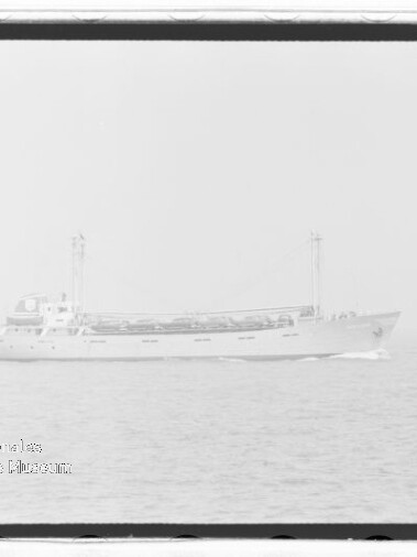 Frachtschiff mit zwei Masten auf ruhiger See, schwaches Wasserzeichen unten links.