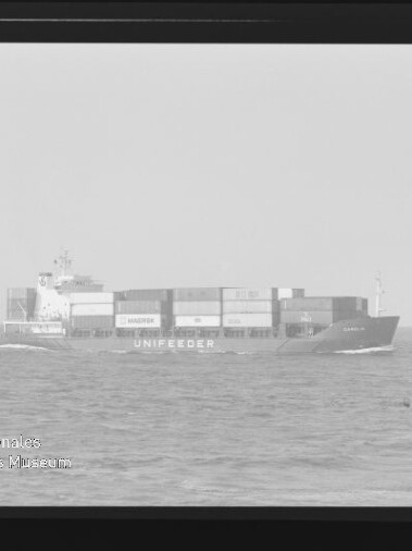 Frachtschiff UNIFEEDER mit gestapelten Containern fährt auf ruhiger See, Horizont und leichter Wellengang sichtbar.