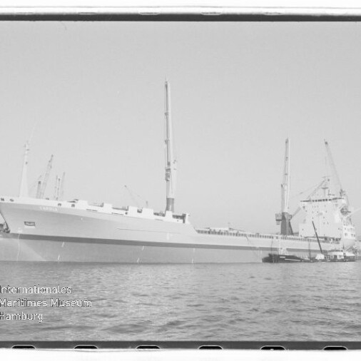 Großes Frachtschiff am Hafenpier mit Ladekränen, Schwarzweißaufnahme; Stempel Internationales Maritimes Museum Hamburg.