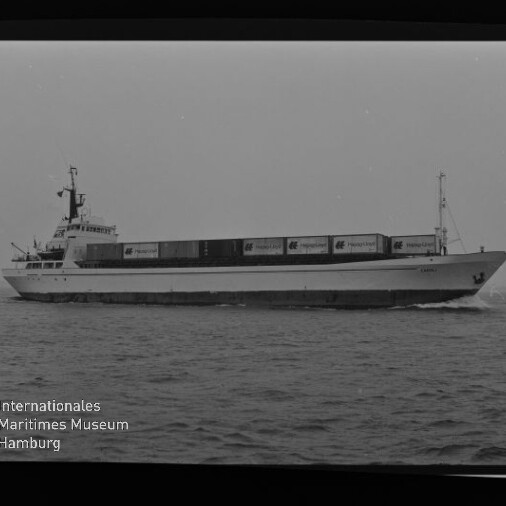 Seitenansicht eines Containerschiffs mit gestapelten Containern auf ruhiger See, Museumssignet unten links.
