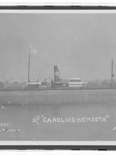 Seitliche Aufnahme des Dampfschiffs S/S Caroline-Hemsoth mit mittigem Schornstein, zwei Masten und ruhigem Wasser.