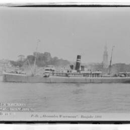 Historisches Passagierdampfschiff Alexandra Woermann (Baujahr 1898) seitlich auf dem Wasser, Ufer mit Gebäuden im Hintergrund.