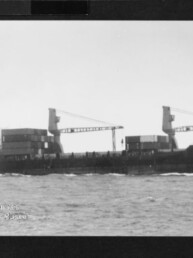 Frachtschiff mit zwei Ladekränen und gestapelten Containern auf offener See, Wasserzeichen des Internationalen Maritimen Museums Hamburg.