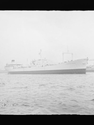 Großes weißes Passagierschiff längsseits im Hafen vor Kränen, ruhige See und Museum-Wasserzeichen links unten.
